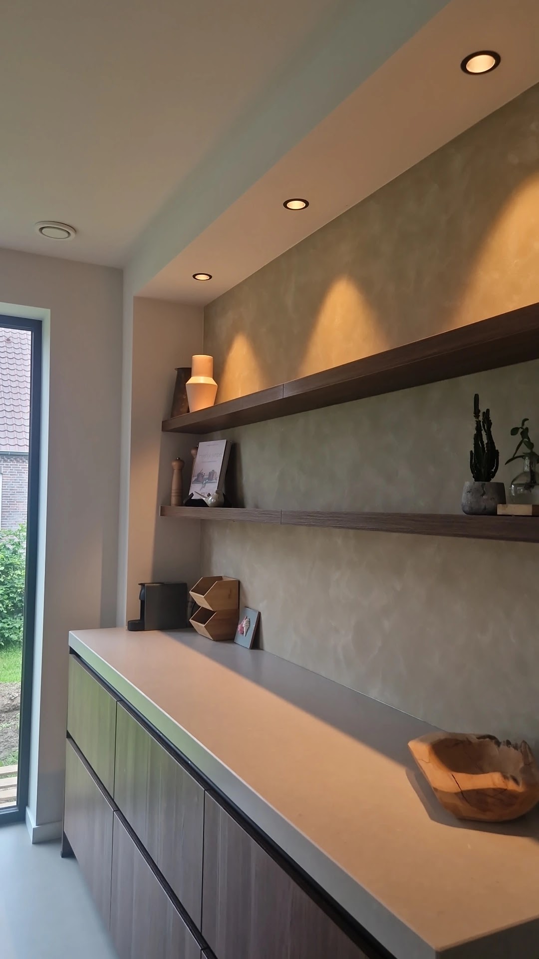 Warme getextureerde keukenwand met houten planken en ingebouwde verlichting